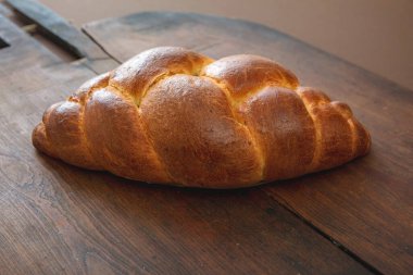Paskalya tatlı ekmeği, ahşap masa arka planında tsoureki cozonac somun, yakın çekim manzarası. Örülmüş brioche, challah. Geleneksel dini bayram tatlısı