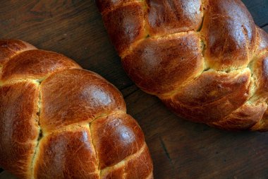 Paskalya tatlı ekmeği, ahşap masa zemininde tsoureki cozonac somunu, üst manzara. Örülmüş brioche, challah. Geleneksel dini bayram tatlısı
