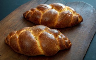 Paskalya tatlı ekmeği, ahşap masa arka planında tsoureki cozonac somun, yakın çekim manzarası. Örülmüş brioche, challah. Geleneksel dini bayram tatlısı