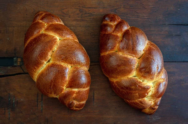 Easter sweet bread, tsoureki cozonac loaf on wood table background, top view. Braided brioche, challah. Festive traditional religion dessert