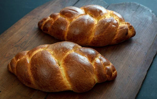 Easter sweet bread, tsoureki cozonac loaf on wood table background, closeup view. Braided brioche, challah. Festive traditional religion dessert