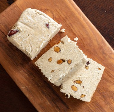 Tahta masa arkasında halva badem ve susam tahini. Vanilya helvası ya da fındıklı Halwa parçaları, üst manzara. Geleneksel tatlı şekerlemesi ayçiçeği tohumlarıyla da yapılır. 