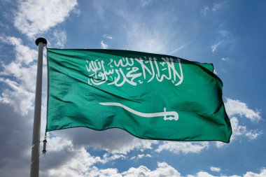 Suudi Arabistan bayrağı, Suudi Arabistan Krallığı mavi bulutlu gökyüzüne doğru dalgalanan bayrak direğinde ulusal bir sembol