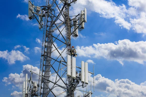 电信维修 在蓝云的天空背景下 人类爬上了塔台 电信站 电视天线无线技术 — 图库照片