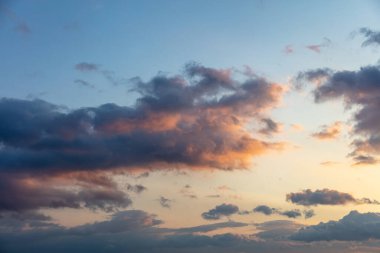 İki bulutun rüzgar kavramına karşı birleşmesi. Şiddetli koyu renkli bulutlu arka planda güneş ışınları, uzay. Güneş ışınlarının ufku boyadığı dramatik soyut sahne.