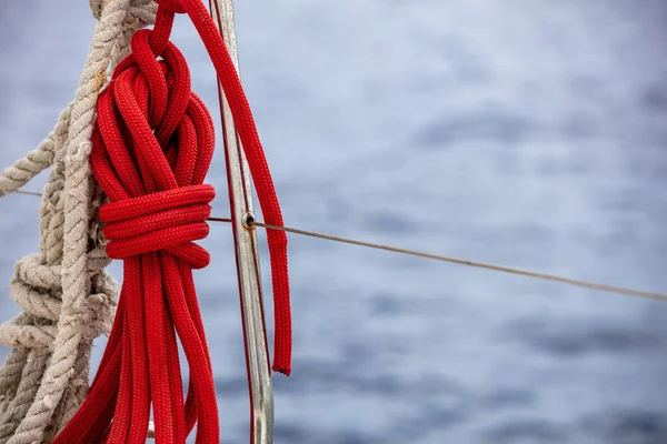 帆船上的帆索 模糊了海水背景 不锈钢护栏上的红色系泊绳 闭合视图 复制空间 游艇巡航卡模板 — 图库照片