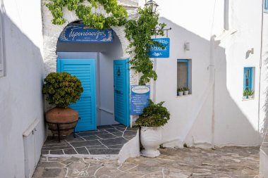 Yunanistan, Sifnos Adası. 19 Mayıs 2021. Geleneksel Yunan mimarisi, otel dükkanları ve Apollonia köyündeki dar kaldırım taşı caddesi, güneşli bir gün.