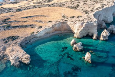 Greece, small Cyclades islands. Koufonisi secluded beach aerial drone view. Rocky cliffs over clear turquise sea water. Sunny day, tranquil summer holidays destinatio clipart