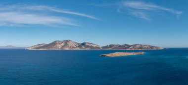 Greece, small Cyclades islands. Aerial drone panoramic view. Keros and Glaronisi islets, Rippled sea water, blue sky background. Secluded destination for relaxatio clipart