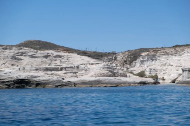 Milos island, Sarakiniko. Cyclades Greece. Moonscape, white color rock formations, cliffs and caves, blue rippled sea and clear sky background. Summer vacation travel destination