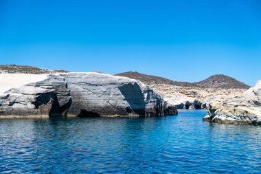 Sarakiniko at Milos island, Cyclades Greece. Lunar landscape. White color rock formations, cliffs and caves, blue rippled sea and clear sky background. Summer vacation travel destination
