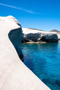 Sarakiniko Milos island, Cyclades Greece. Lunar landscape, white color rock formations, cliffs and caves, blue rippled sea and clear sky background. Summer vacation travel destination