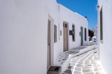 Whitewashed buildings, narrow cobblestone street. Mykonos island, Greece. Chora village traditional architecture white color. Summer vacations destination, Cyclades. Empty wall, space, card template