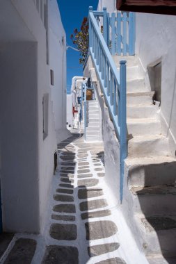 Whitewashed buildings, narrow cobblestone street. Mykonos island, Cyclades Greece. Chora village traditional architecture, stairs and white and blue colors. Summer vacations destination,