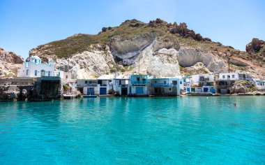 Milos island, Cyclades Greece. Firoporamos or Fyropotamos fishing village, Cycladic architecture traditional fishermen houses and turquoise clear sea water. White rock and blue sky background. clipart