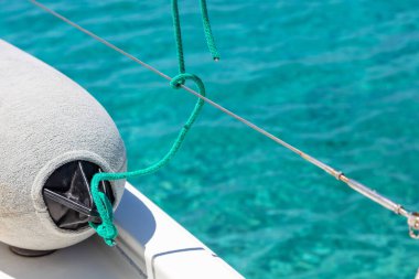 Yat güvertesinde yelkenli çamurluğu, turkuaz mavi deniz suyu arka planı, yelkenli bumber kapanışı, Ege Denizi, Yunanistan 'da yaz gezisi, kopya alanı, kart şablonu.