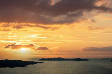 Ege Denizi üzerinde gün batımı, Varış noktası Yunan adaları, Santorini Kiklad, Yunanistan. Sakin su, renkli bulutlu arka plan, yaz tatili seyahat turizmi.