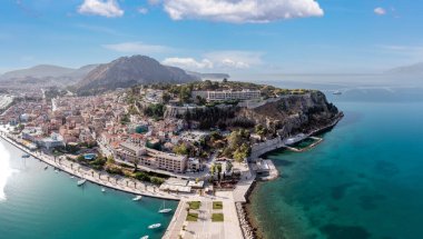 Yunanistan, Nafplion ya da Nafplio şehri, insansız hava aracı manzaralı. Moreloponnese eski şehir manzarası, Palamidi şatosu yokuş yukarı, rıhtıma demirlemiş yatlar ve tekneler. Bulutlu mavi gökyüzü.