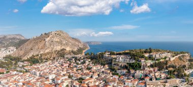 Yunanistan, Nauplion ya da Nafplio şehri, hava aracı manzaralı. Eski şehir manzarası, Palamidi şatosu yokuş yukarı. Bulutlu mavi gökyüzü ve sakin deniz arkaplanı.