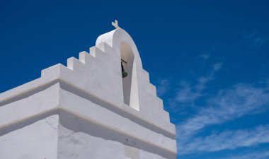 Yunan adası, Kiklad Yunanistan. Dini haçlı geleneksel beyaz ortodoks kilisesi ve açık mavi gökyüzü arka planına karşı çan. Yaz romantik düğün davetiyesi şablonu, kopyalama alanı
