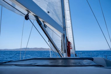 Açık okyanusta yelkenli yelkenli yelkenli, mavi gökyüzü arka planı, güneşli bir gün. Yelkenli güvertesi, pruva, yelken direği ve yelkenli yakın görüntü. Ege Denizi, Kiklad adalarında yaz tatili, Yunanistan