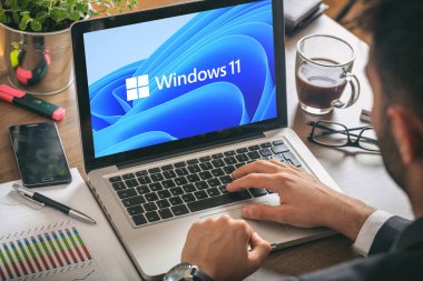 Yunanistan, 8 Temmuz 2021. Bir dizüstü bilgisayarla çalışan adam, Windows 11 bilgisayar ekranında yeni Microsoft işletim sistemi, iş masası geçmişi.