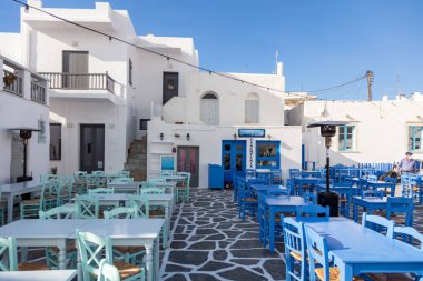 Yunanistan, Paros Adası Naousa eski limanı. 20 Mayıs 2021. Kiklad. Geleneksel açık kafe bar ve taverna. Mavi boş masa ve sandalyeler, Yunan balıkçı köyü, popüler turizm beldesi