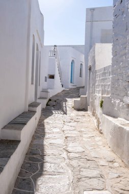Yunanistan, Sifnos Adası. Apollonia Chora köyü. Geleneksel Yunan mimarisi, beyazlatılmış binalar ve dar kaldırım taşı geçidi, güneşli bir gün. Kapalı dükkanlar, boş sokaklar
