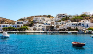 Yunanistan Kiklad 'ı. Sifnos adası, Faros balıkçı köyü. Geleneksel deniz binaları, Ege Denizi 'ne demirlemiş balıkçı tekneleri, açık mavi bir arka plan. Yaz tatilleri