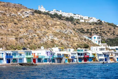 Kiklad Yunanistan. Milos adası, Klima 'nın sahildeki balıkçı köyü ve Trypiti' nin tepesi. Rıhtım manzaralı, renkli kapıları ve pencereleri olan geleneksel balıkçı evleri..