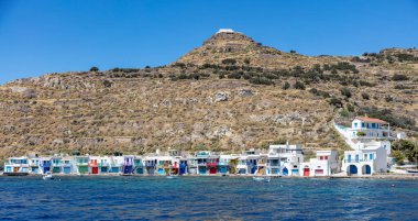 Kiklad Yunanistan. Deniz kenarındaki geleneksel balıkçılar, deniz manzaralı, renkli kapıları ve pencereleri olan beyaz renklilere ev sahipliği yapar. Milos Adası, Klima balıkçı köyü panoraması,