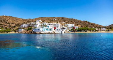 Sifnos adası, Faros köyü, Kiklad Yunanistan. Açık mavi turkuaz şeffaf deniz beyazlatılmış geleneksel kumlu binalar. Güneşli bir gün yaz tatili. Yüzme, rahatlama..