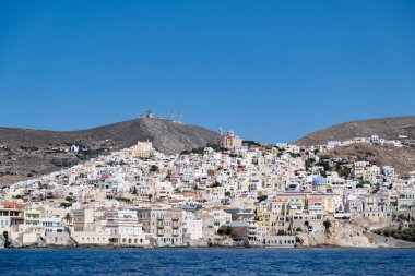 Syros Adası, Cyclades, Yunanistan. Ermoupolis şehri, tepenin üzerindeki deniz manzaralı geleneksel binalar. Güneşli yaz günü, mavi gökyüzü