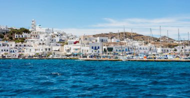 Milos Adası, Adamas limanı, Cyclades Yunanistan. 17 Mayıs 2021. Limana demir atmış yelkenli tekneler, bembeyaz binalar, dalgalı deniz, mavi gökyüzü, deniz manzarası.