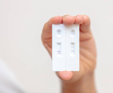 Covid 19 pozitif ve negatif sonuçlara sahip insan eli hızlı testler, antikorları tespit etmek için ekipmanlar. Coronavirus kendi kendini test ediyor, enfeksiyon ve bağışıklık sistemi.