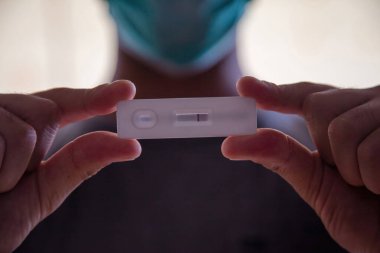 Coronavirus negatif sonuç hızlı test, evde yapılan testler, kovansı 19 'la el ele tutuşan adam, antikorları ve bağışıklığı tespit etmek için alet çantası. Yakın görünüm, seçici odak