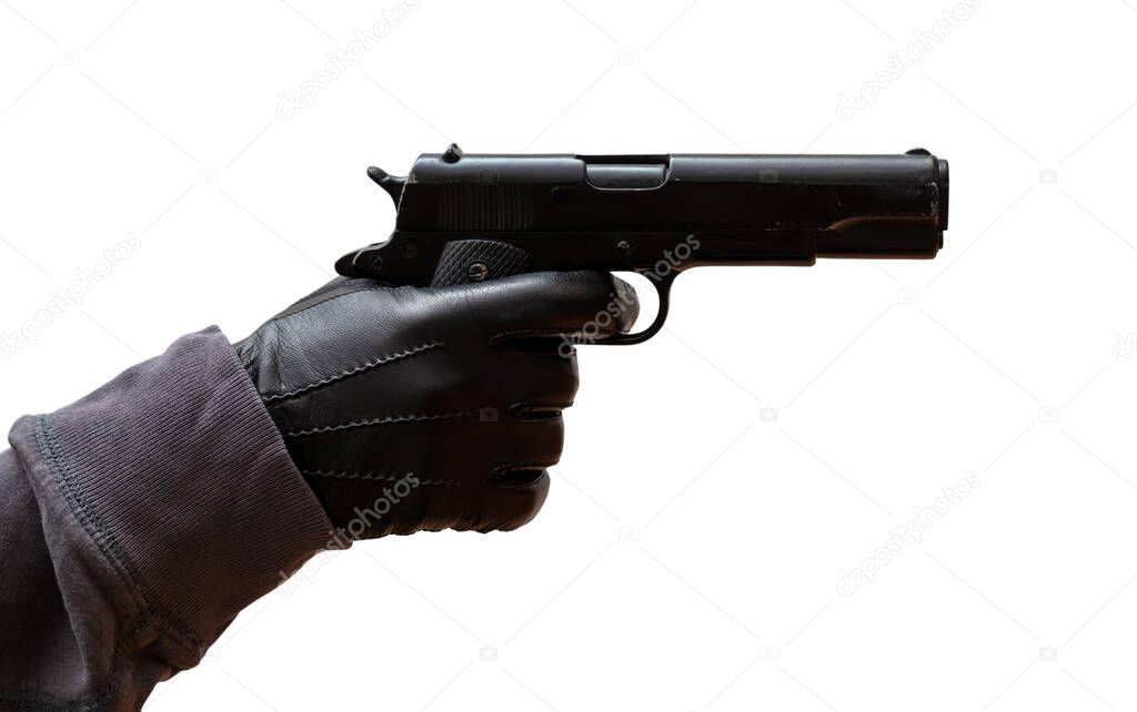 Pistol in gloved hand. Gunman wearing leather gloves aiming with a gun isolated on white background, closeup view. Killer, murderer concept