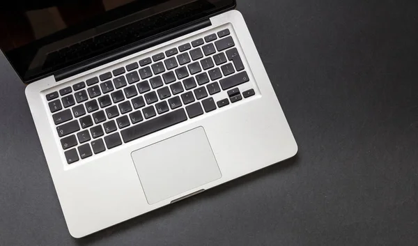 黒い色の背景にコンピュータのラップトップ ノートパソコンのキーボードのメタルシルバートップビューを開きます ホームオフィスのコンセプト コピースペース テンプレート — ストック写真