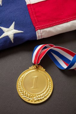 ABD için altın madalya. Siyah arka planda Amerikan bayrağı ve kurdeleli ödülün sahibi. Amerikan atlet kupası birincilik için sporda.
