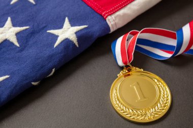 ABD için altın madalya. Siyah arka planda Amerikan bayrağı ve kurdeleli ödülün sahibi. Amerikan atlet kupası birincilik için sporda.