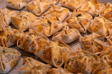 Yunanistan 'ın Girit adasının Kaltsounia geleneksel yemekleri. Kalitra peynirli susam tohumlu ev yapımı, ev yapımı, sağlıklı hamur tatlısı. Ballı yumurta. Düğün davetlileri için tatlı ya da tuzlu ikram.