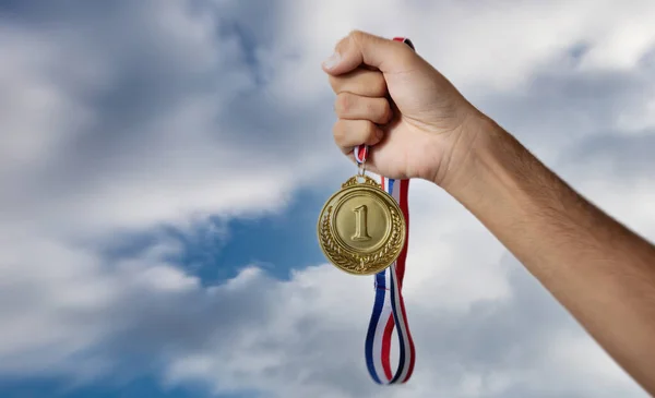 Mano Que Sostiene Medalla Oro Contra Fondo Nublado Del Cielo — Foto de Stock