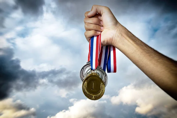 Медали Руке Спортсмена Против Драматического Неба Награда Победителя Золотое Серебро — стоковое фото