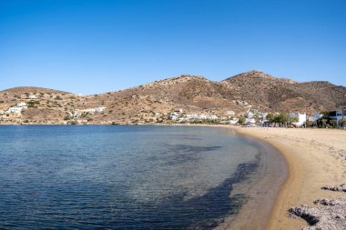Gialos boş kumsal Yialos ya da Port Ios, Nios adası Cyclades 'in Yunanistan' ı. Deniz kenarındaki beyaz binalar mavi gökyüzünün altında Ege Denizi 'nin yanında dinlenmek için altın yumuşak kum yüzer yaz tatilinde.