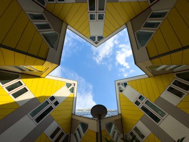 Cube houses in Rotterdam Netherlands. Yellow color modern architecture design. Low angle view, sunny day, blue cloudy sky