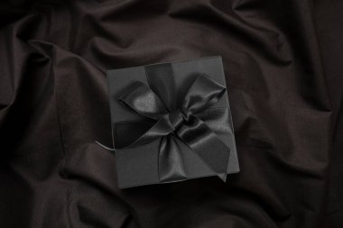 Kara Cuma satışları, siyah tekstil üzerine ipek kurdeleli bir hediye kutusu, kış tatili hediyeleri.
