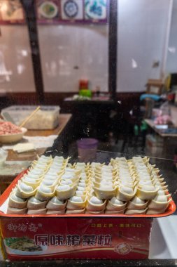 Şangay, Çin, 29 Mart 2025. Küçük bir dükkânın içinde kırmızı tepside duran el yapımı hamur tatlısı camdan görülüyor.