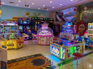 Pekin, Çin, 23 Mart 2025. Modern bir eğlence merkezinde elektronik oyun makineleri ve neon ışıkları olan bir atari salonu.