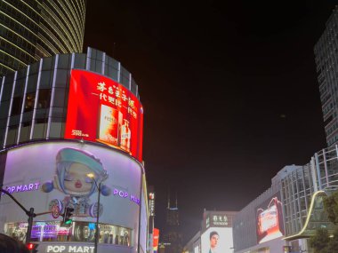 Şangay, Çin, 30 Mart 2025. Parlak reklam panoları ve modern binalar Şangay şehir merkezindeki gece manzarasını aydınlatıyor.
