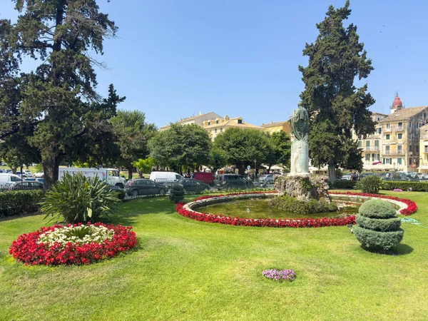 Korfu, Yunanistan, 6 Haziran 2025. Bronz heykel ve dairesel bir çeşme, manikürlü bahçe, St. Michael ve St. George Sarayı 'ndaki renkli çiçekler ve ağaçlar.
